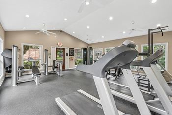 A gym with treadmills, weights, and exercise equipment.